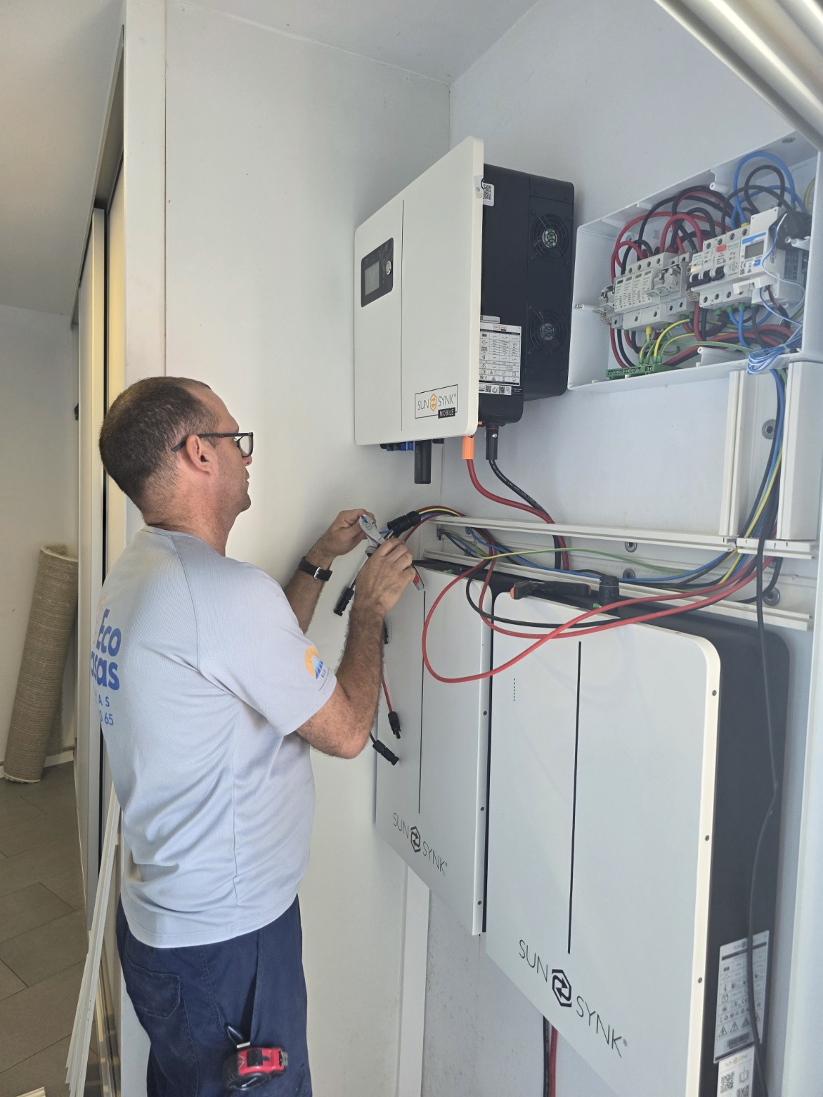 Técnico configurando inversor, baterías y protecciones de una instalación fotovoltaica